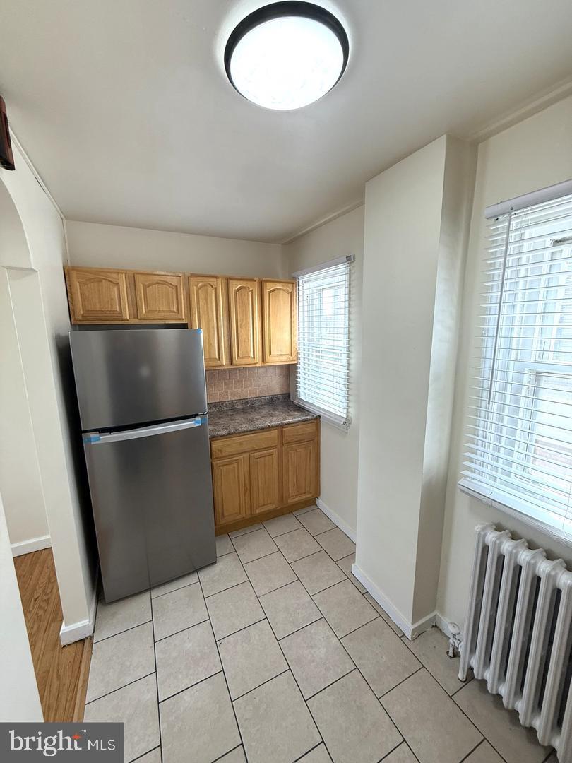 5223 Jackson Street, Unit 2F Philadelphia, PA 19124 - Photo 8 of 12 a kitchen with granite countertop a refrigerator a sink a stove a microwave and cabinets