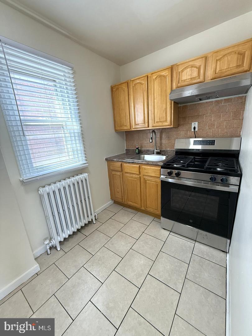 5223 Jackson Street, Unit 2F Philadelphia, PA 19124 - Photo 9 of 12 a kitchen with stainless steel appliances granite countertop a stove a sink and a microwave