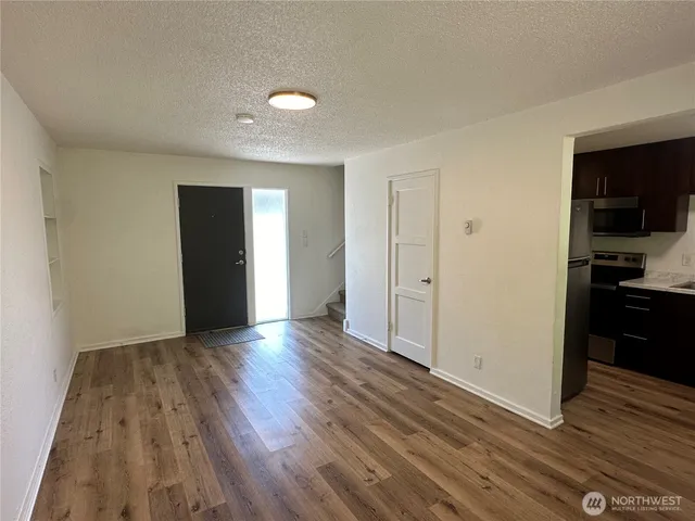 a view of empty room with wooden floor and cabinets