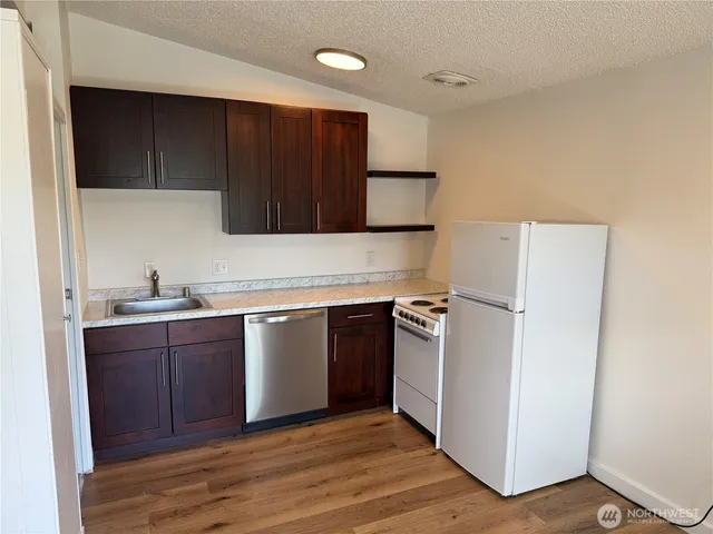a kitchen with a refrigerator sink and cabinets