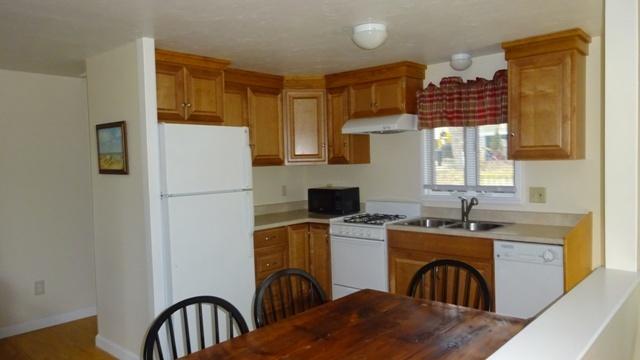 27 Hideaway Road, Unit G Buzzards Bay, MA 02532 - Photo 8 of 34 a kitchen with stainless steel appliances granite countertop a sink a stove a refrigerator cabinets a dining table and chairs