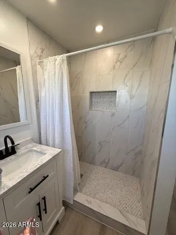a bathroom with a granite countertop sink and a mirror