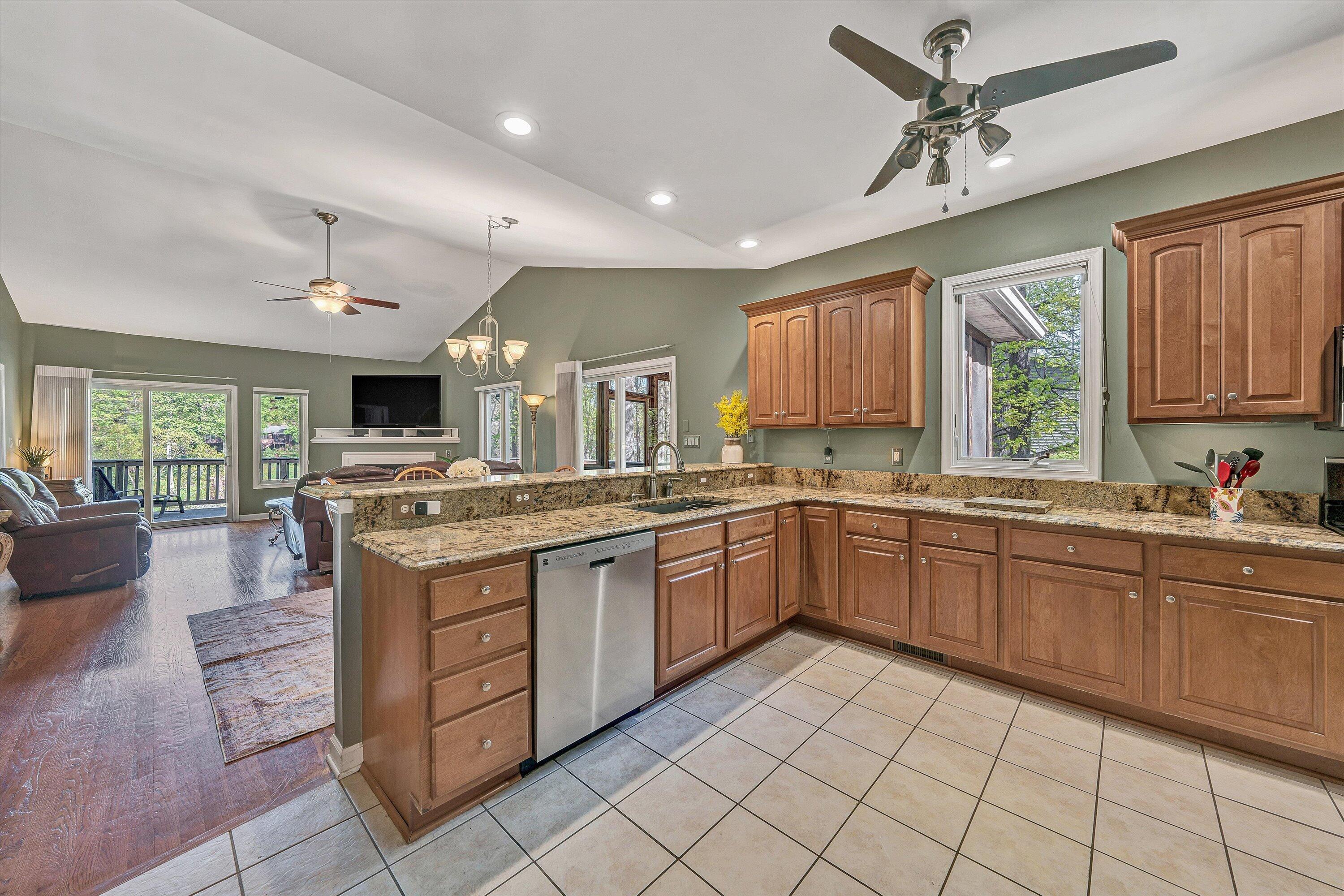 145 Channelview Drive Moneta, VA 24121 - Photo 25 of 62 a large kitchen with kitchen island granite countertop a stove a sink dishwasher and white cabinets with wooden floor