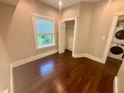 an empty room with wooden floor and washing machine
