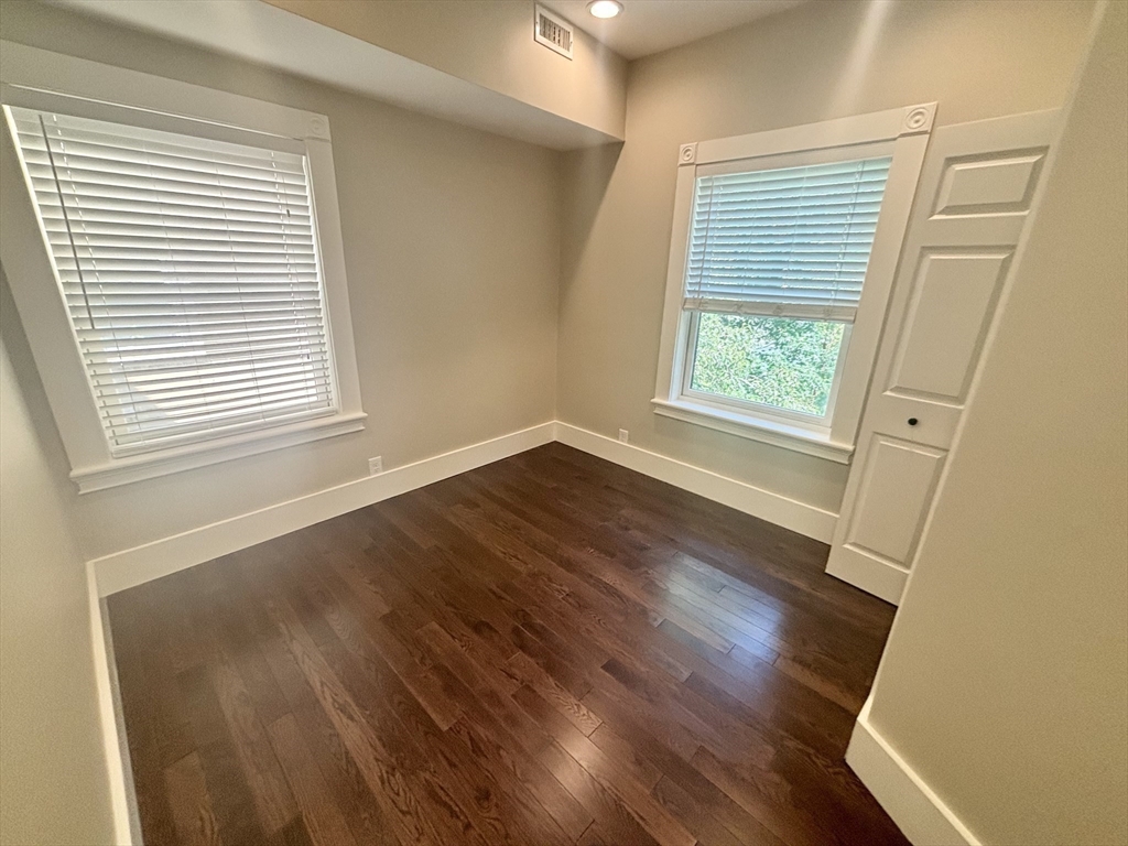 48 Magazine Street, Unit 3 Cambridge, MA 02139 - Photo 12 of 15 an empty room with wooden floor and windows