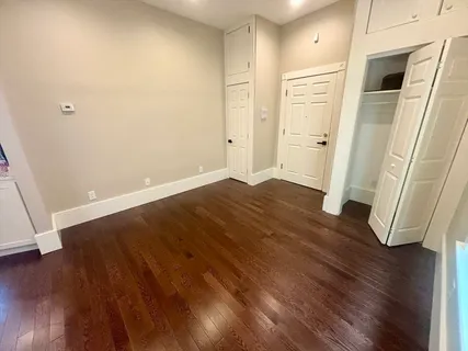 an empty room with wooden floor and entrance