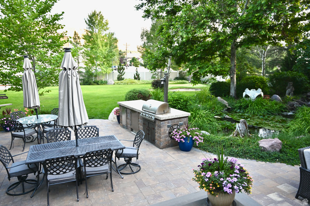 314 Brown Farm Lane Draper, UT 84020 - Photo 36 of 57 Expansive outdoor patio featuring paver stones, a built-in outdoor kitchen with a grill, and a tranquil water feature