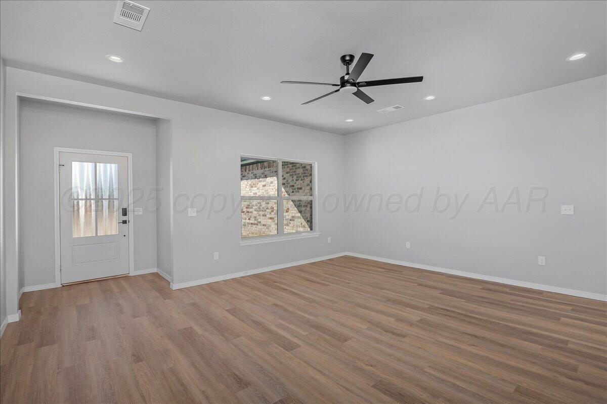 4206 Beacon Road Amarillo, TX 79118 - Photo 6 of 23 an empty room with wooden floor fan and windows