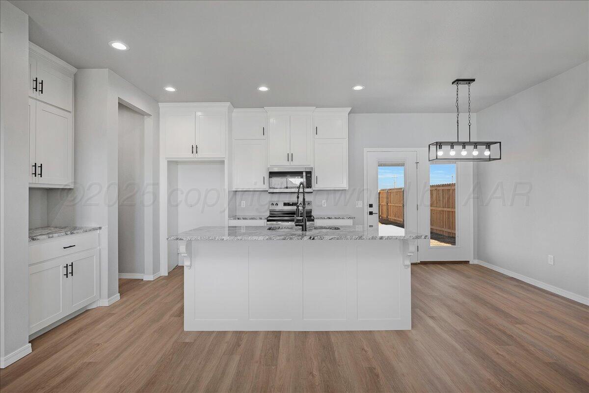 4206 Beacon Road Amarillo, TX 79118 - Photo 7 of 23 a view of a kitchen with kitchen island a island wooden floor stainless steel appliances and cabinets