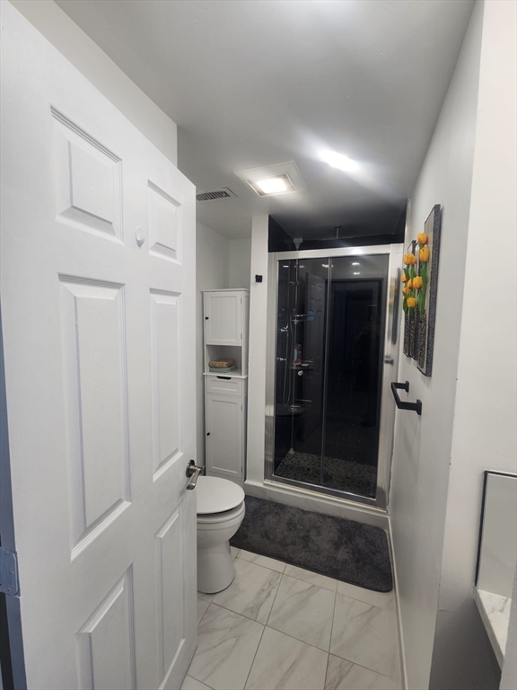 1203 Bennington Street Boston, MA 02128 - Photo 8 of 25 a bathroom with a glass door shower and toilet