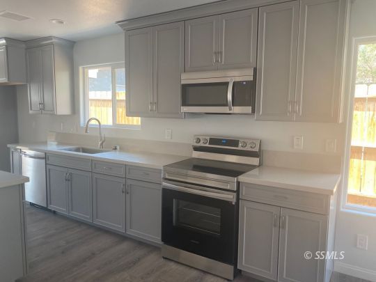 1009 West Boston Avenue Ridgecrest, CA 93555 - Photo 2 of 9 a kitchen with white cabinets stainless steel appliances and sink