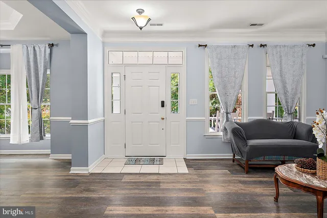 a view of a dining room with furniture a chandelier and wooden floor