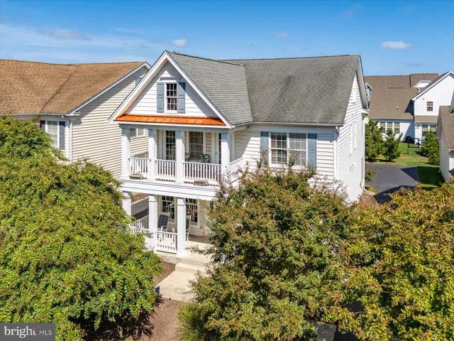 a view of a white house with large windows and a small yard