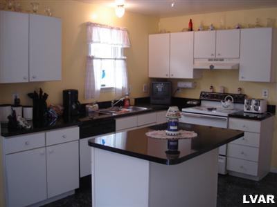 2 County Park Road Gilbert, PA 18331 - Photo 5 of 10 a kitchen with granite countertop a sink a stove and cabinets
