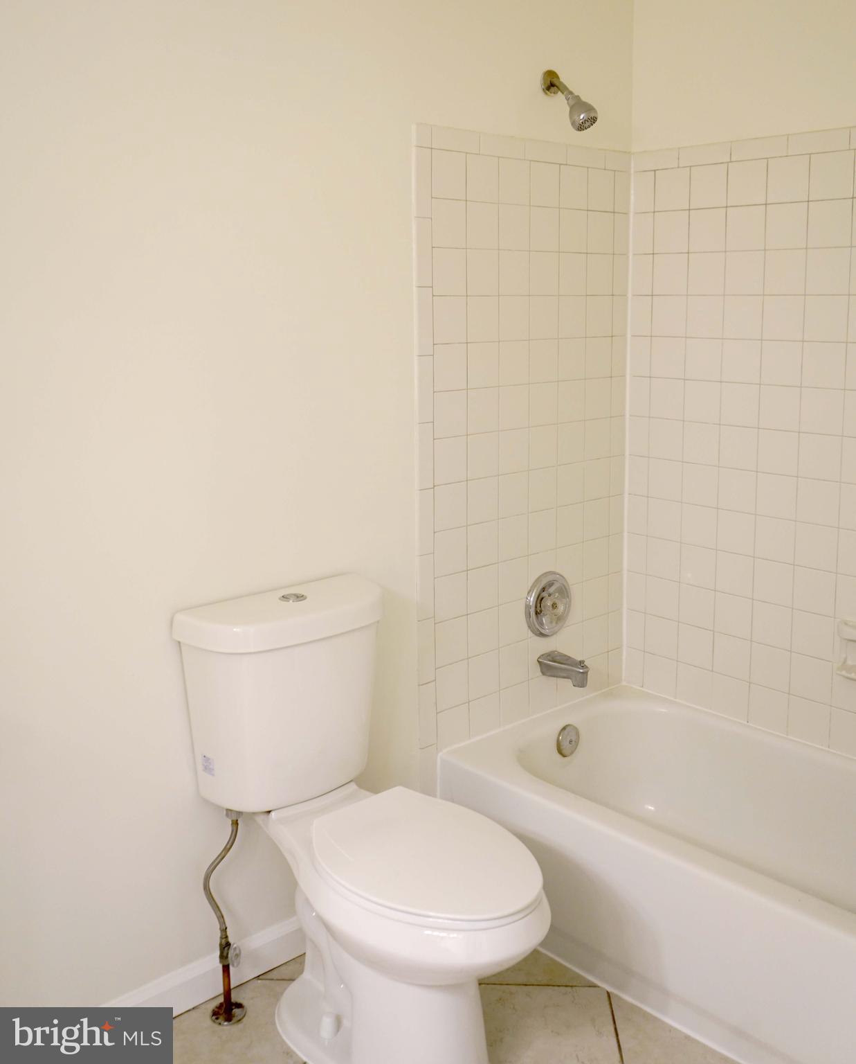 12004 Amber Ridge Circle, Unit B303 Germantown, MD 20876 - Photo 9 of 25 a white toilet sitting next to a bath tub and a shower