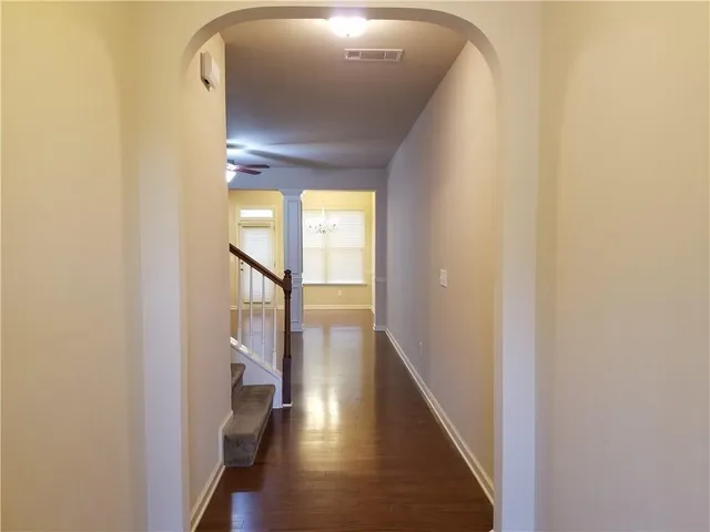 a view of a hallway with wooden floor and entryway