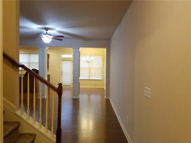 a view of a hallway with wooden floor and staircase