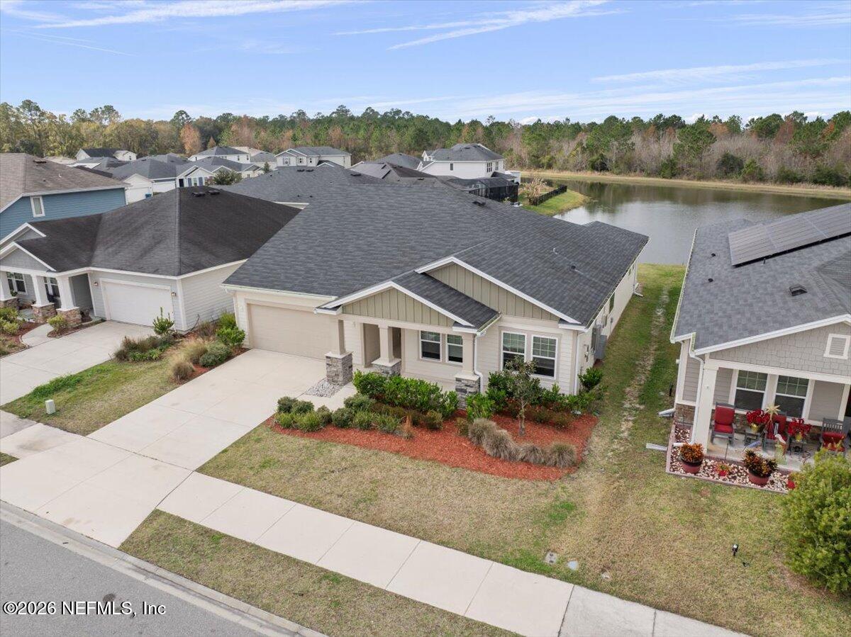 an aerial view of a house with a garden and lake view