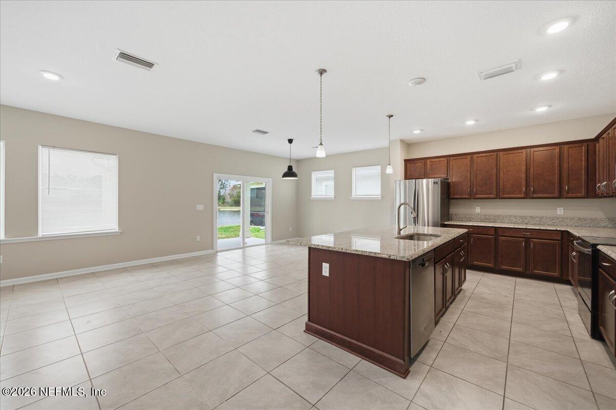 12032 Bridgehampton Road Jacksonville, FL 32218 - Photo 17 of 52 a kitchen with stainless steel appliances granite countertop a stove and a sink