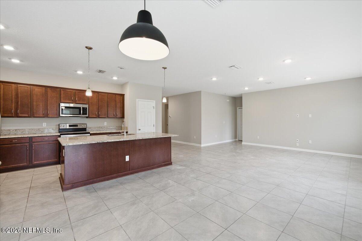 12032 Bridgehampton Road Jacksonville, FL 32218 - Photo 22 of 52 a large kitchen with stainless steel appliances granite countertop a large counter top a sink and a stove
