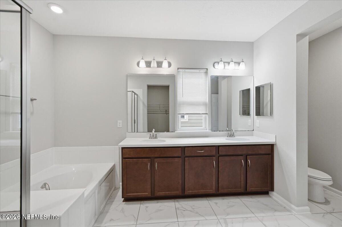 12032 Bridgehampton Road Jacksonville, FL 32218 - Photo 29 of 52 a bathroom with a tub sink and mirror
