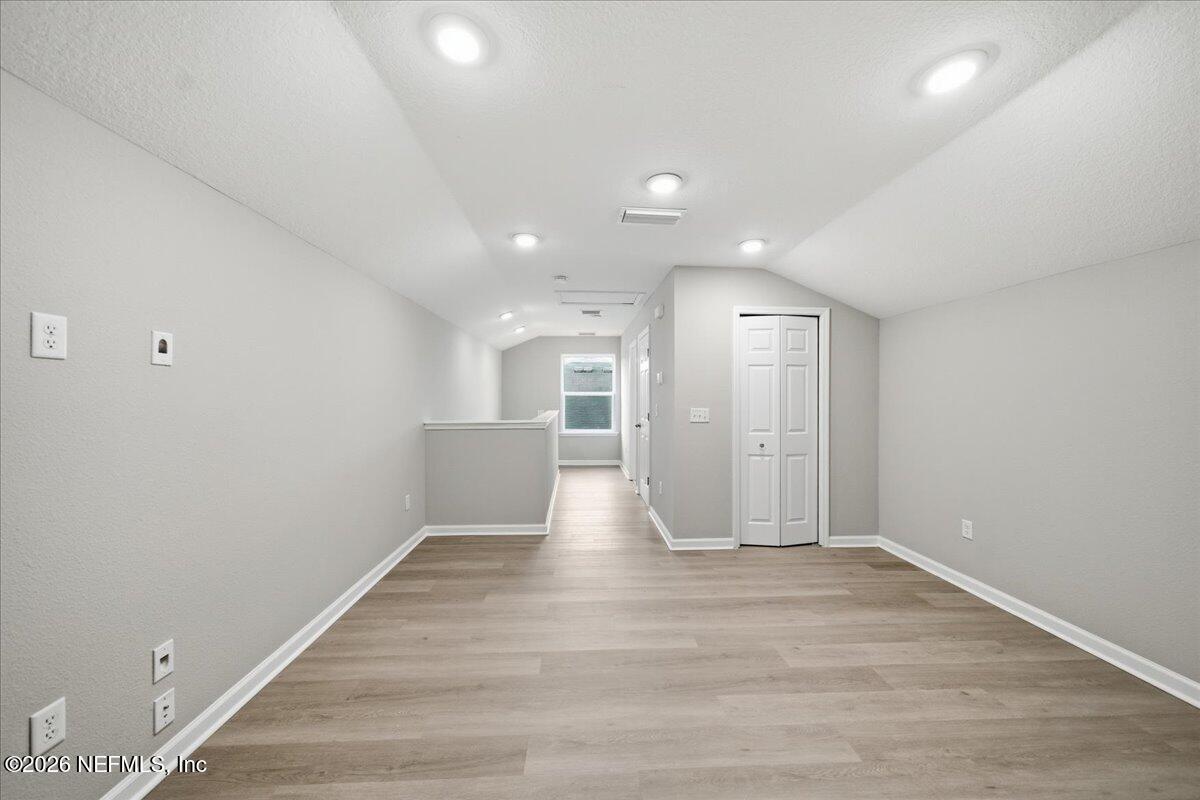 12032 Bridgehampton Road Jacksonville, FL 32218 - Photo 33 of 52 a view of an empty room with wooden floor and a window