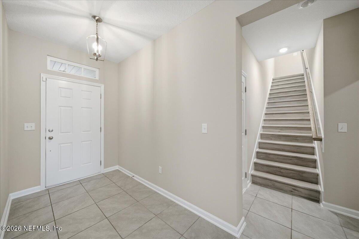 12032 Bridgehampton Road Jacksonville, FL 32218 - Photo 8 of 52 a view of a hallway with stairs and chandelier