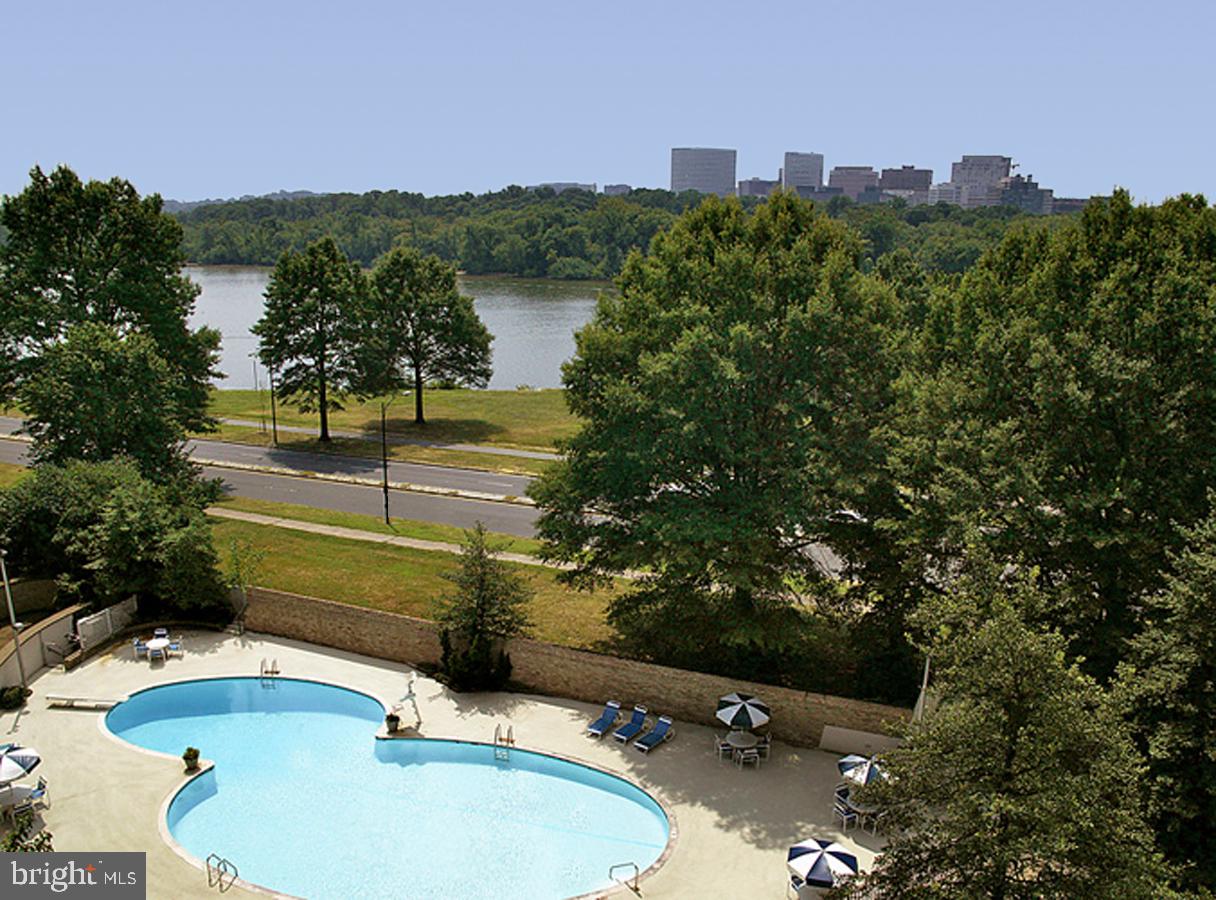 2700 Virginia Avenue Northwest, Unit 109 Washington, DC 20037 - Photo 32 of 47 a view of a swimming pool with a yard and large trees