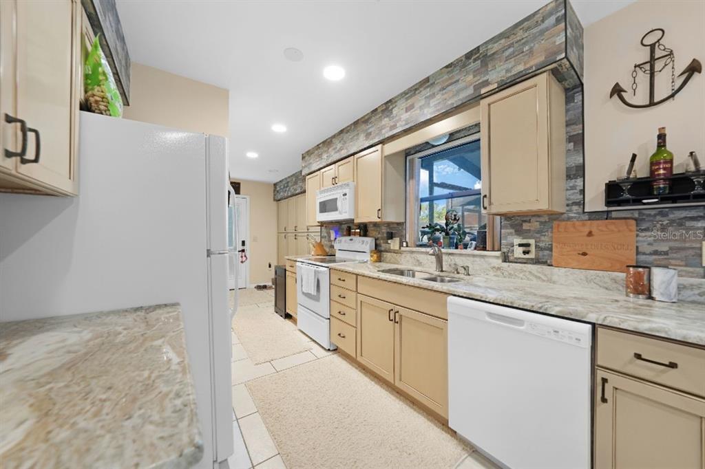 13064 Feldman Avenue Port Charlotte, FL 33981 - Photo 4 of 13 a kitchen with stainless steel appliances granite countertop a sink and cabinets
