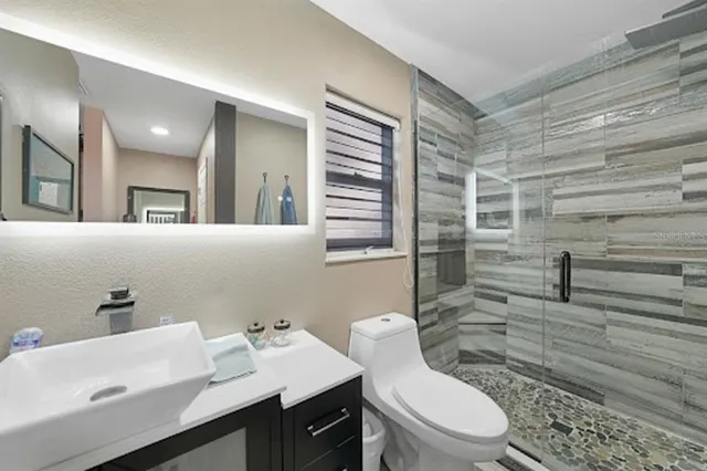 a bathroom with a sink a toilet and shower