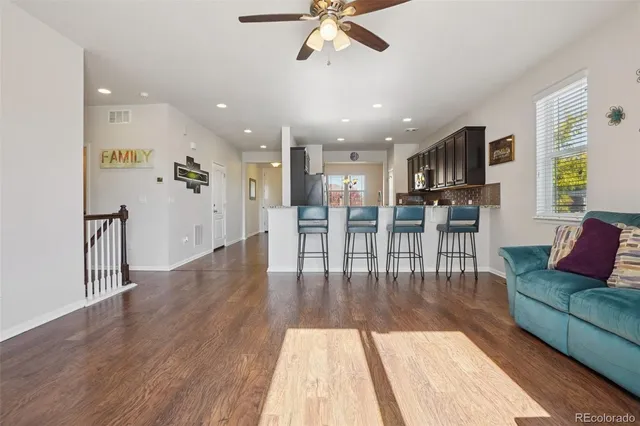 a living room with furniture and a wooden floor