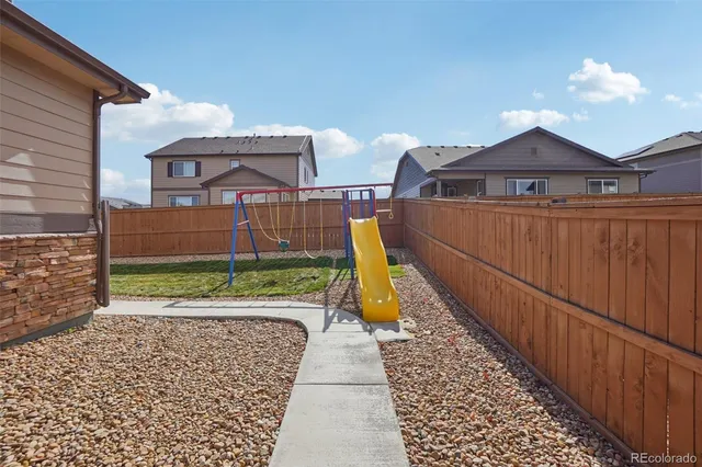 a view of a brick house with wooden fence