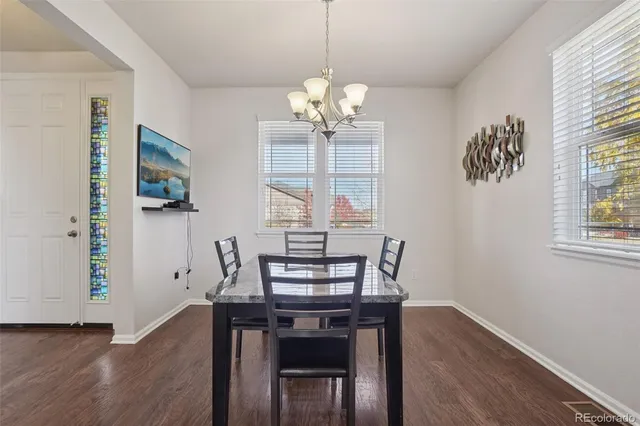 a view of a dining room with furniture a chandelier and wooden floor