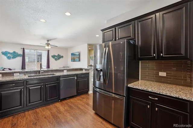 a kitchen with stainless steel appliances granite countertop a refrigerator and a sink