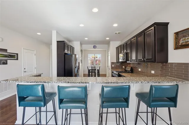 a kitchen with granite countertop cabinets a sink and chairs