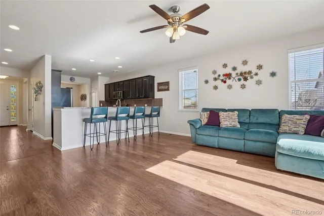 a living room with furniture and a view of kitchen
