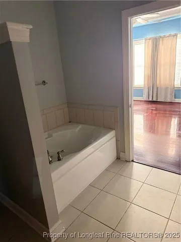 a bathroom with a bathtub and a window