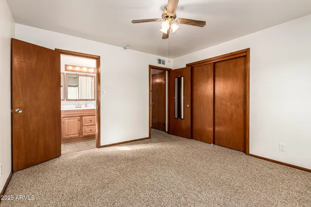 a view of an empty room with a chandelier fan