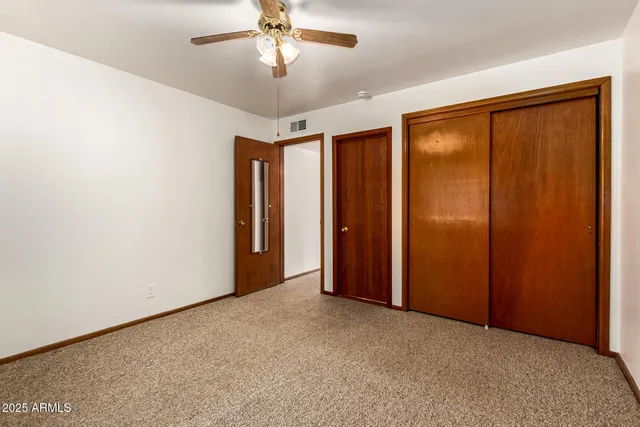 an empty room with chandelier fan
