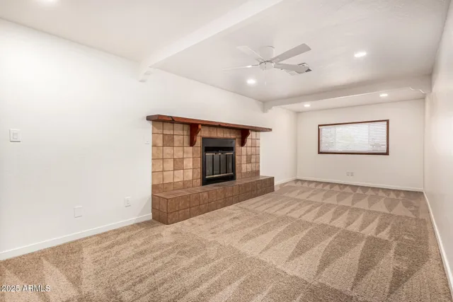 a view of an empty room with a fireplace and a window
