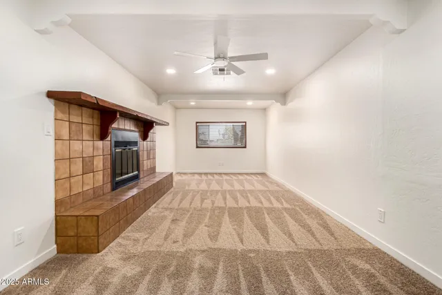 an empty room with windows and fireplace