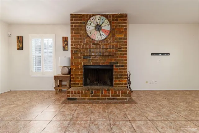 a living room with a fireplace windows a rug and a clock