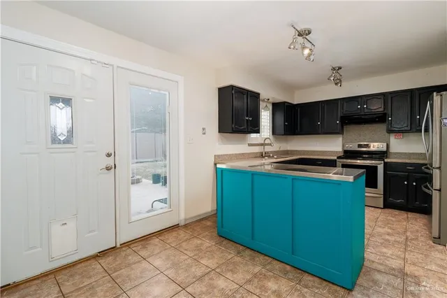 a kitchen with stainless steel appliances granite countertop a refrigerator and a stove top oven