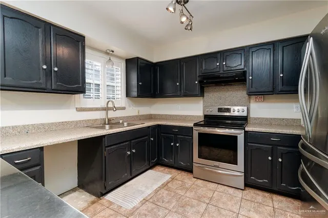 a kitchen with a sink cabinets and stainless steel appliances