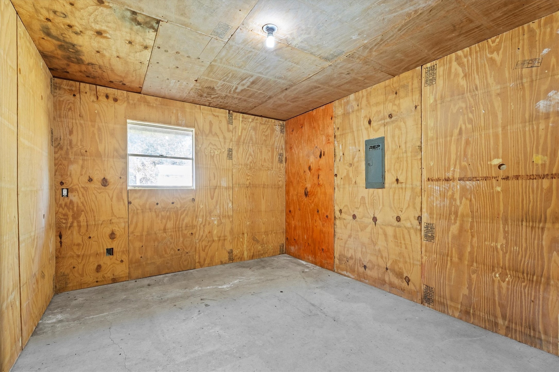 104 Anna Street Tomball, TX 77375 - Photo 17 of 32 This is a versatile room added to the garage as part of the conversion. Walls and ceiling are lined with plywood and well-insdulated with the exception of a single window for natural light, and a concrete floor. It is virtually soundproof. The home's electric panel is located in this room.