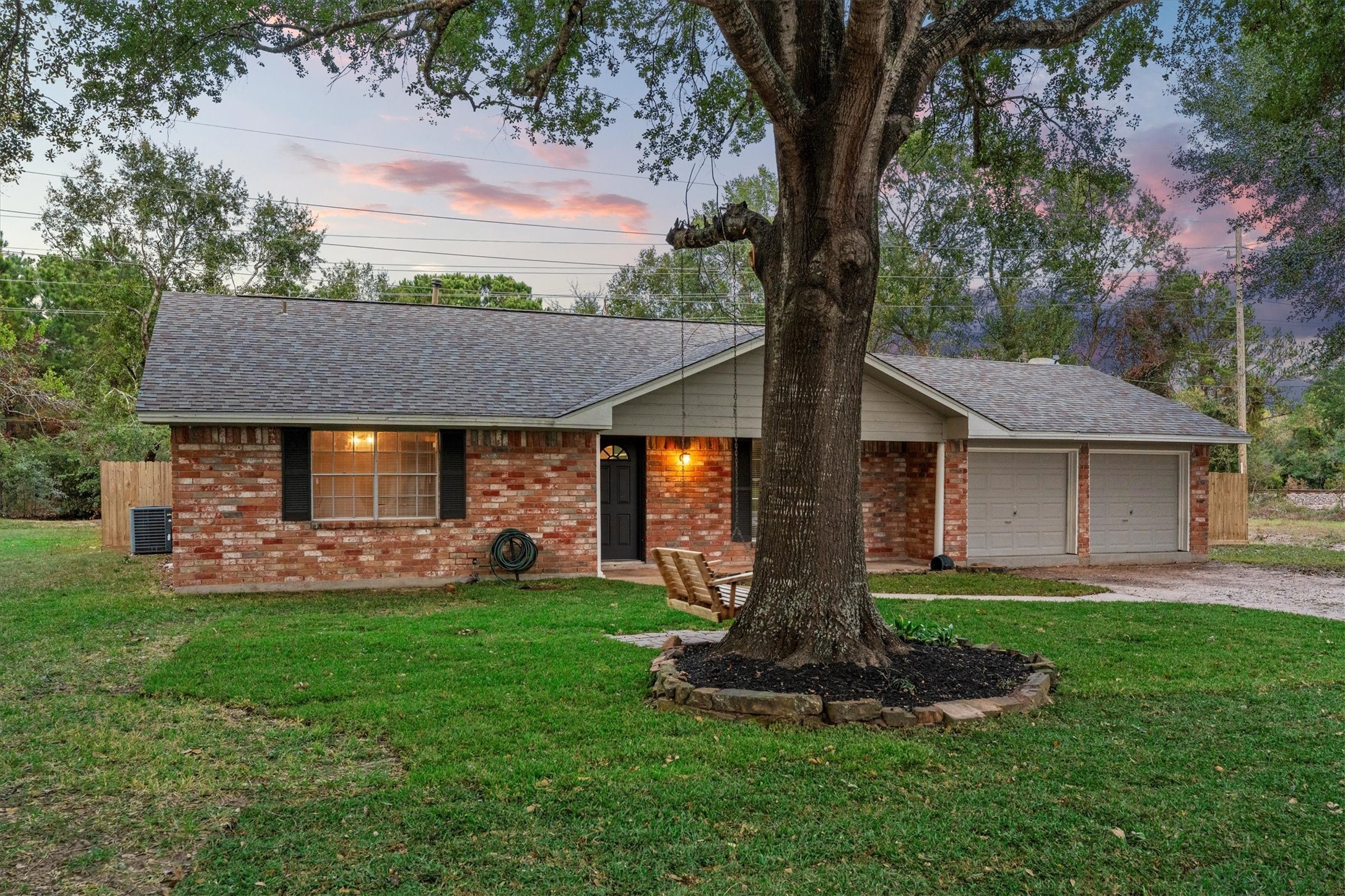 104 Anna Street Tomball, TX 77375 - Photo 24 of 32 Here's another view of the front elevation at dusk. The property offers a spacious lawn and a peaceful neighborhood setting.
