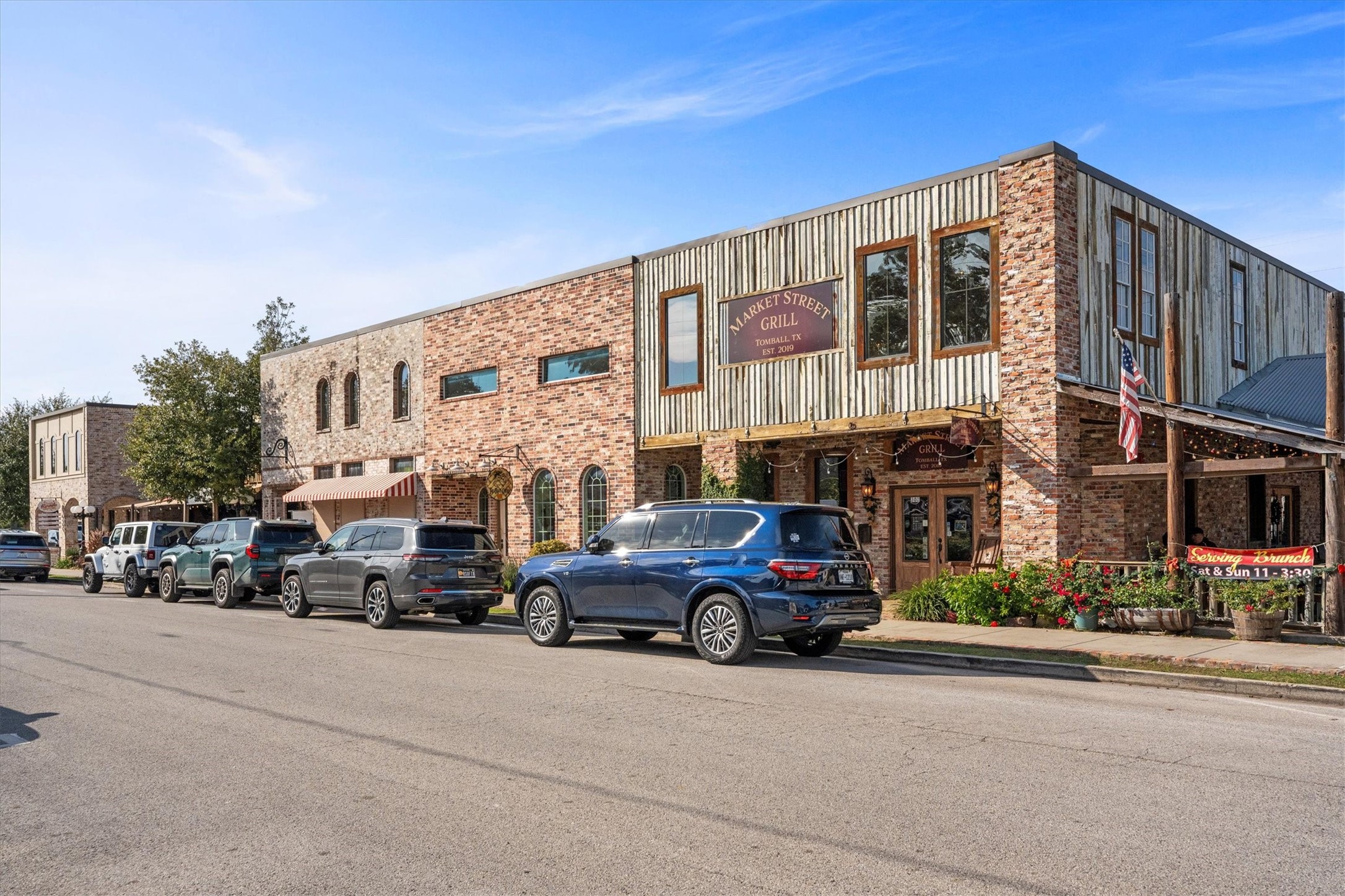 104 Anna Street Tomball, TX 77375 - Photo 30 of 32 Charming downtown area with a rustic brick building featuring a restaurant. The street is lined with parked cars and a few trees, creating a cozy and inviting atmosphere. Perfect for those who enjoy a vibrant, small-town community feel with plenty of shops and restaurants.