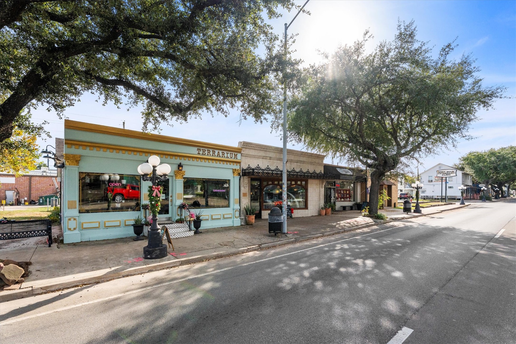 104 Anna Street Tomball, TX 77375 - Photo 31 of 32 Charming small-town street featuring quaint shops, including a terrarium store. The area is lined with mature trees and has a welcoming, pedestrian-friendly vibe—ideal for those seeking a community-oriented lifestyle.