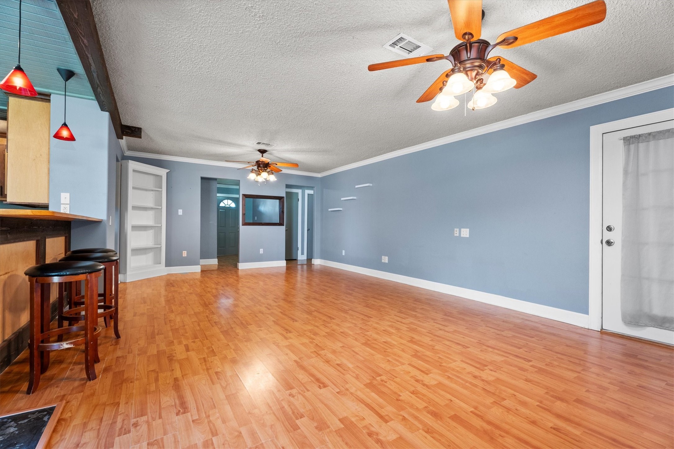 104 Anna Street Tomball, TX 77375 - Photo 8 of 32 View of the spacious living area from the dining area. Features built-in shelves, two ceiling fans and back door to the covered patio.