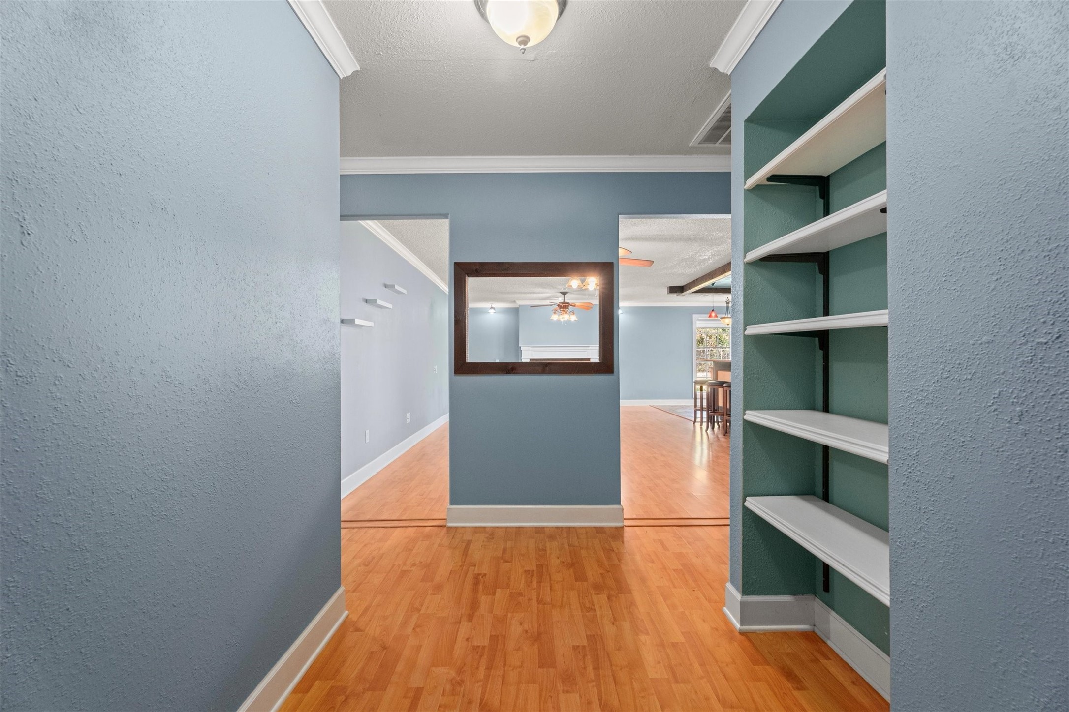 104 Anna Street Tomball, TX 77375 - Photo 9 of 32 As you enter the home, you can see all the way to the back of the house. The foyer/entry features built-in shelving on the right. You can pass through to the living area on either side of the open window wall/partition. There's one bedroom down the hall to the right and the other two bedrooms and bath are down the hall to the left.